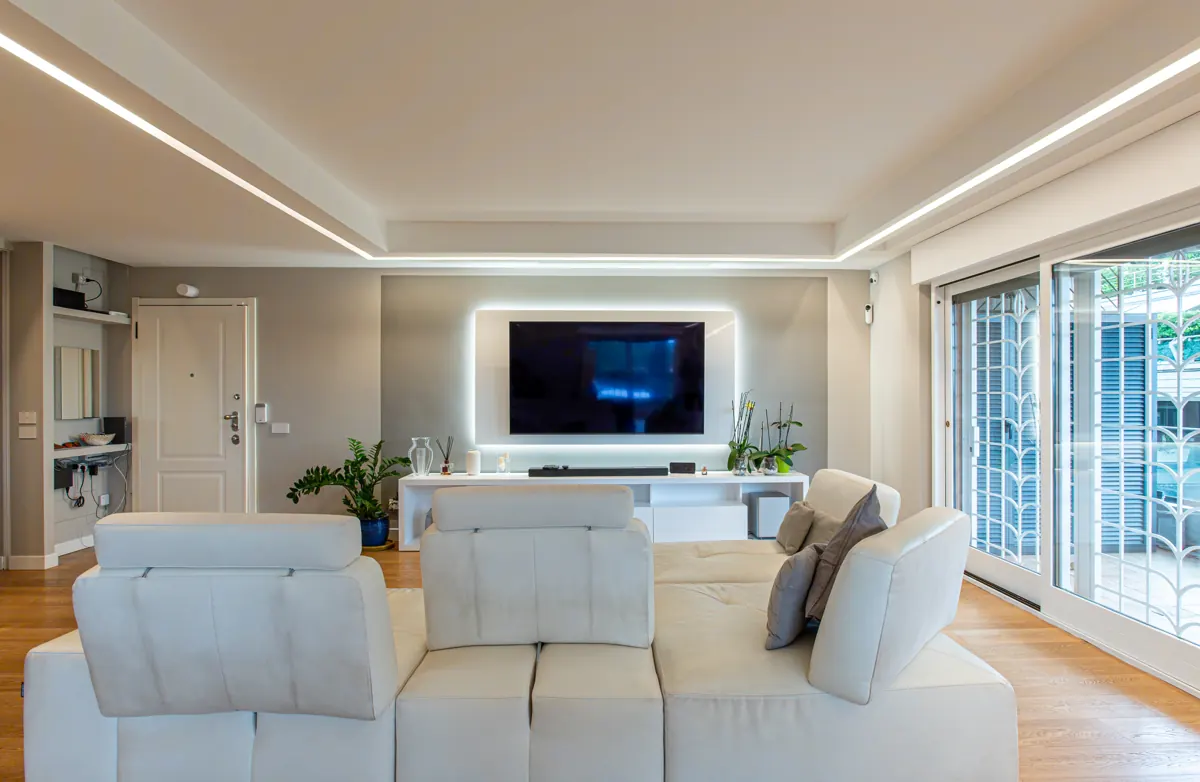 Living completato con divano, parquet e illuminazione su misura, dopo la ristrutturazione