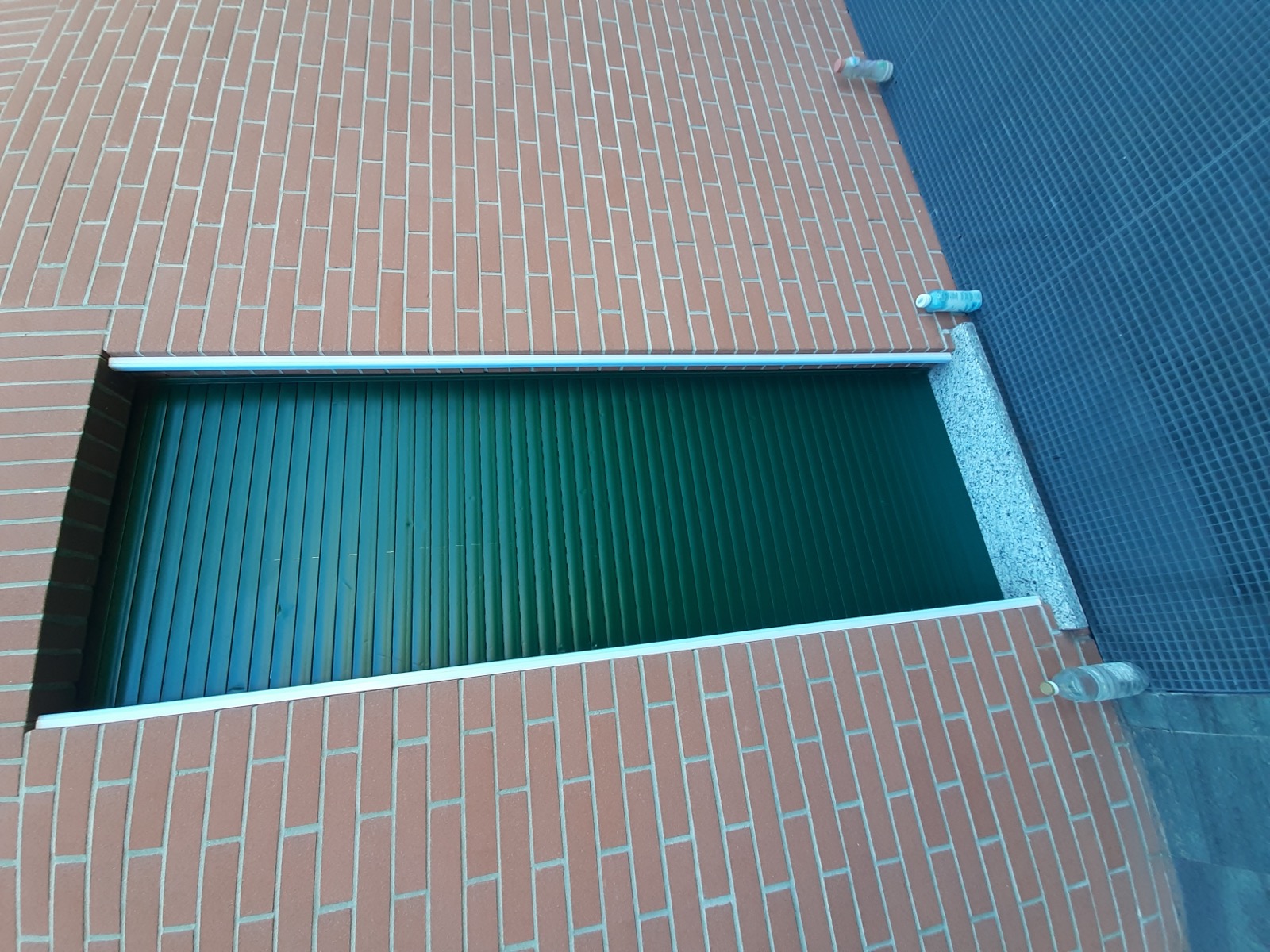 Serranda di sicurezza in metallo installata su un edificio in mattoni